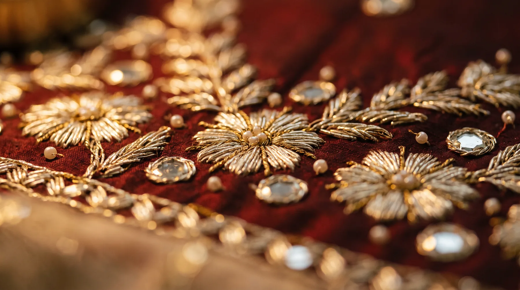 Zardozi embroidery detail in oxblood and gold